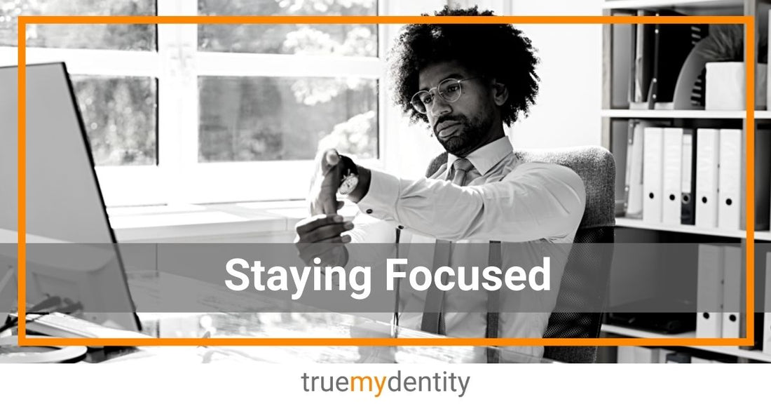 young professional male at desk in office staying focused by stretching arms hands while working True Mydentity