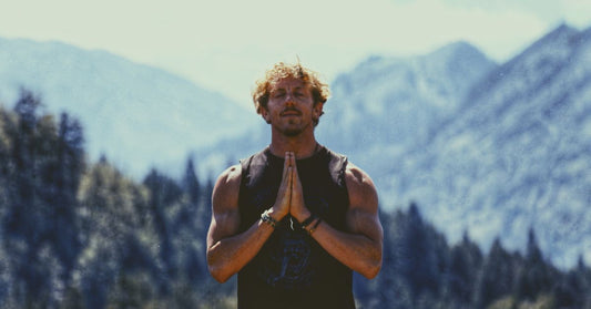 man on mountains eyes closed hands together giving thanks showing gratitude grateful person