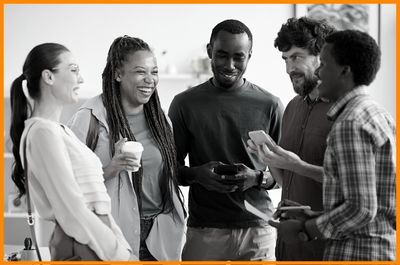 Group of professionals dressed casually laughing using fair character trait to discuss approach to project