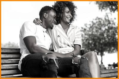 man woman couple smiling embracing each other on park bench both with empathetic character