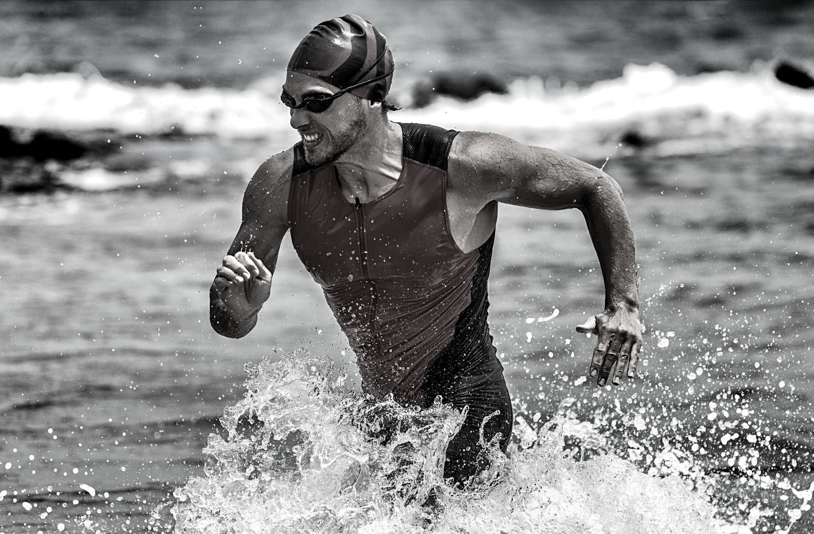 determined male triathlete grimacing while running through shallow water