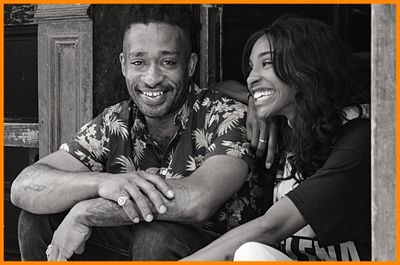 man and woman smiling while sitting on front step