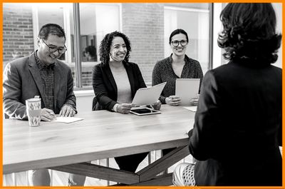 woman interviewing for position with three team leaders business creative design department