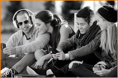 young-friends-couples-sitting-together-on-pavement-sharing-smiling-laughing-about-cell-phone-content